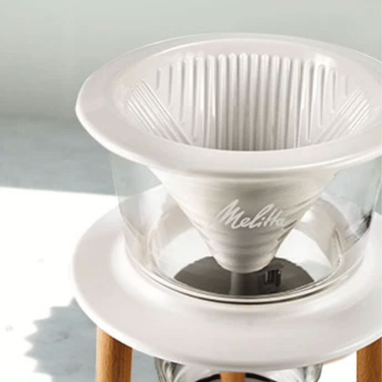 White Melitta coffee filter on a white stand with a light gray background